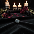 Black obsidian heart pendant on dark velvet with candlelight