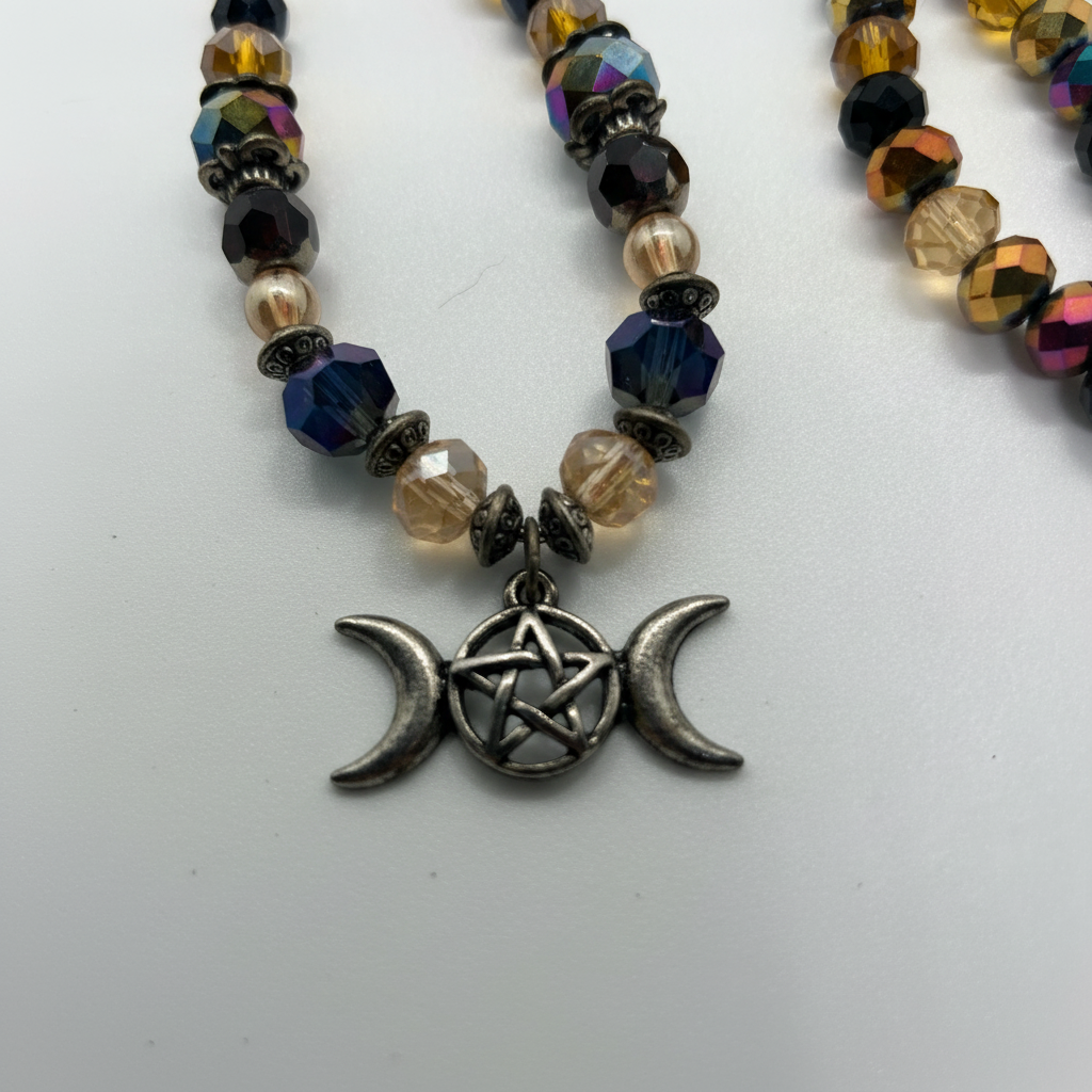 Triple moon pentagram crystal beaded necklace close-up on pendant on white studio background
